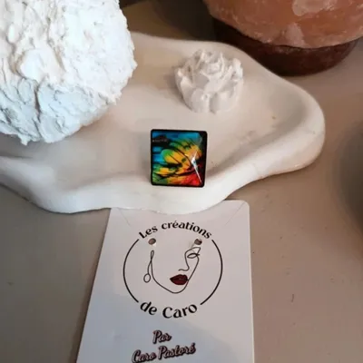 Bague ajustable cabochon carré motif plumes multicolores 